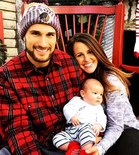 Kirk Cousins posing with wife Julie Hampton and their son